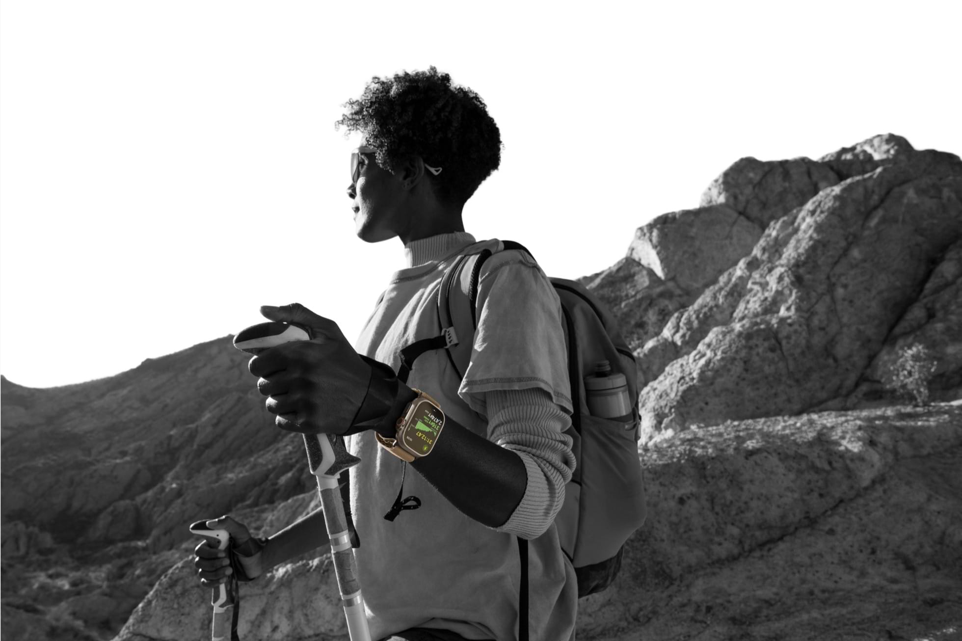 מטייל עם תיק גב ומקלות הליכה בנוף הררי, עם Apple Watch Ultra 4 על היד. צילום: Apple
